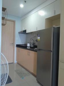 a kitchen with a stainless steel refrigerator and cabinets at Grass residences in Manila