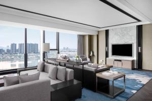 Marriott Nanjing South Hotel في Jiangning: غرفة معيشة بها أريكة وتلفزيون