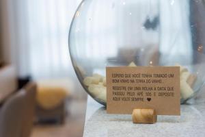 a sign sitting on a table next to a glass bowl at Villa di Tondo House II-Lindo apartamento in Bento Gonçalves