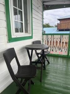 duas cadeiras e uma mesa no alpendre de uma casa em Hostal Cay em Bastimentos