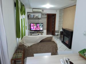 a living room with a couch and a television at Vista para o Guaíba in Porto Alegre