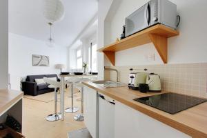 cocina y sala de estar con encimera en Superbe duplex à proximité du Sacré Coeur!, en París