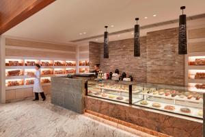 a woman standing in front of a bakery at Zhuhai Marriott Hotel in Zhuhai