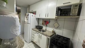 a kitchen with a white refrigerator and a sink at Apartamento no Rosarinho in Recife