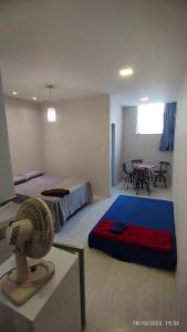 a room with two beds and a table with a fan at Apartamento central particular in Lavras