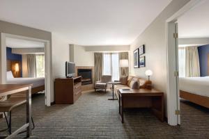 a hotel room with a bed and a living room at Residence Inn Sacramento Folsom in Folsom