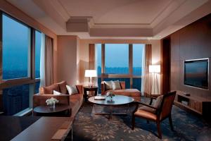 a living room filled with furniture and a large window at Shanghai Marriott Hotel Pudong East in Shanghai