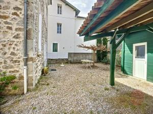 un patio de un edificio con un cobertizo verde en Maison Lamalou-les-Bains, 4 pièces, 6 personnes - FR-1-451-45, en Lamalou-les-Bains