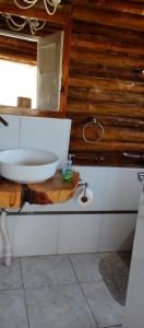 La salle de bains est pourvue d'un lavabo sur un comptoir en bois. dans l'établissement INCA ROCA Cabañas de Montaña, à Uspallata