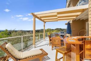 patio con mesa y sillas en el balcón en Ourania Luxury Villa with unforgettable sea views, en Rye