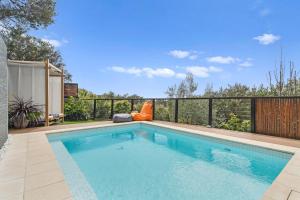 a swimming pool in a backyard with a fence at Ourania Luxury Villa with unforgettable sea views in Rye