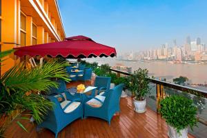 a balcony with blue chairs and a table and an umbrella at Sheraton Chongqing Hotel in Chongqing