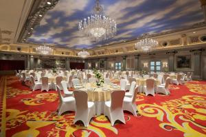 Sheraton Chongqing Hotel في تشونغتشينغ: قاعة احتفالات كبيرة مع طاولات بيضاء وكراسي بيضاء