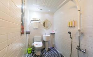 Un pequeño baño con inodoro y espejo. en Hera drive in hotel, en Jeju 39 fotos más
