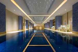 奉賢的住宿－上海聖淘沙萬怡酒店（原新發展聖淘沙大酒店），墙壁和天花板上设有蓝色瓷砖的游泳池