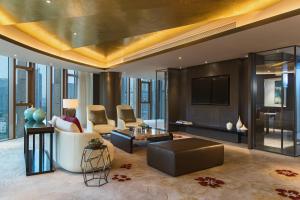 a living room with a couch and a tv at Renaissance Nanjing Olympic Centre Hotel in Nanjing