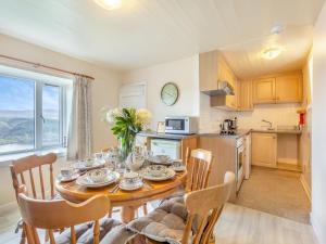 een keuken en eetkamer met een tafel en stoelen bij Bunloit Farmhouse - Uk45397 in Lewiston