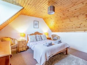 een slaapkamer met een bed en een houten plafond bij Bunloit Farmhouse - Uk45397 in Lewiston