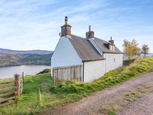 een oud wit gebouw op een heuvel naast een weg bij Bunloit Farmhouse - Uk45397 in Lewiston