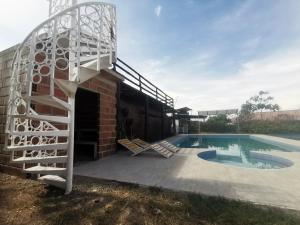 a house with a swimming pool and a spiral staircase at QUINTA RANCHO SANTIAGO CAMPESTRE capacidad 50 huéspedes in Yaguará