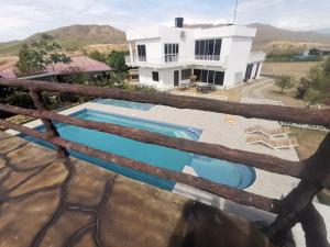 a villa with a swimming pool in front of a house at QUINTA RANCHO SANTIAGO CAMPESTRE capacidad 50 huéspedes in Yaguará