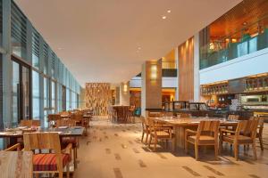 a restaurant with wooden tables and chairs and windows at Four Points by Sheraton Chengdu, Pujiang Resort in Pujiang
