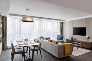 Marriott Executive Apartments Chongqing في تشونغتشينغ: غرفة معيشة مع أريكة وطاولة
