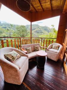 ein Wohnzimmer mit 2 Stühlen und einem Tisch auf der Veranda in der Unterkunft Tropical House in La Vega