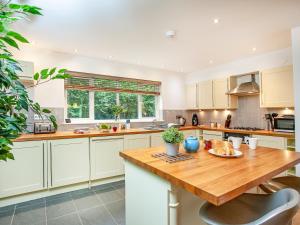 a kitchen with white cabinets and a wooden table at Haven -78 in Perranwell