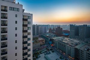 a view of a city at sunset from a building at Le Meridien Shenyang Heping in Shenyang