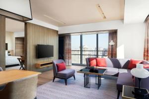 a living room with a couch and a tv at Le Meridien Shenyang Heping in Shenyang