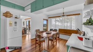 a kitchen and dining room with a table and chairs at Bermagui Breeze Holiday House 5 bedroom 18-20 Mumbulla Street - Bermagui in Bermagui