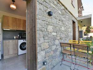a stone wall in a kitchen with a washing machine at Appartement Samoëns, 2 pièces, 4 personnes - FR-1-391-178 in Samoëns