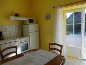 eine Küche mit einem Tisch und einem weißen Kühlschrank in der Unterkunft Gîte Vennecy, 3 pièces, 4 personnes - FR-1-590-392 in Vennecy