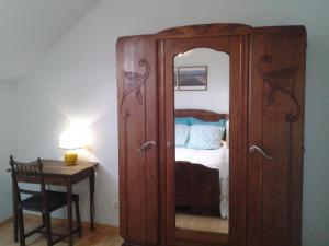 ein Holzschrank mit einem Spiegel neben einem Bett in der Unterkunft Gîte Vennecy, 3 pièces, 4 personnes - FR-1-590-392 in Vennecy