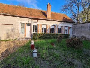 ein altes Haus mit einem Hydranten davor in der Unterkunft Gîte Bucy-Saint-Liphard, 1 pièce, 2 personnes - FR-1-590-413 