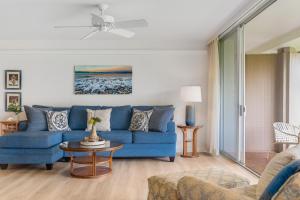 a living room with a blue couch and a table at Eldorado H107 in Kahana