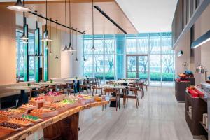 a large room with tables and chairs and windows at Courtyard by Marriott Shanghai Minhang in Shanghai