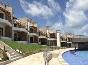 - un grand bâtiment avec une piscine en face dans l'établissement Dream Away Pipa Residence, à Pipa
