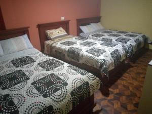 duas camas sentadas uma ao lado da outra num quarto em Hostal Locuras en el Cielo em Baños