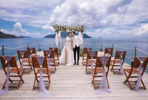 a bride and groom walking down the aisle at their wedding ceremony at Six Senses Con Dao - Turtle Island Paradise in Con Dao