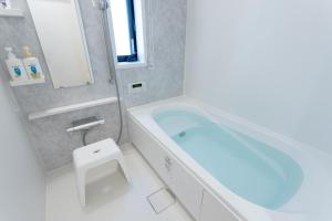 a bathroom with a blue tub and a sink at Shinjuku City House 新宿シティハウス in Tokyo