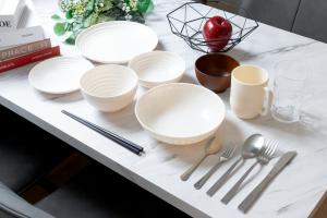 a table with white plates and utensils on it at Shinjuku City House 新宿シティハウス in Tokyo