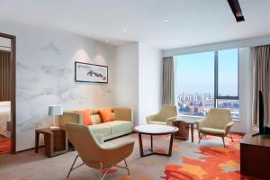 a living room with a couch and a table and chairs at Four Points by Sheraton Changchun Hi-Tech Zone in Changchun