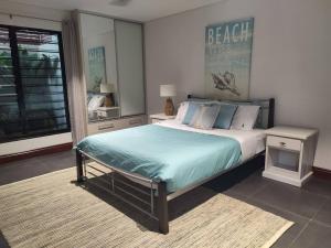 Un dormitorio con una cama grande y una ventana en Lush Tropical Paradise Home - Darwin City en Stuart Park