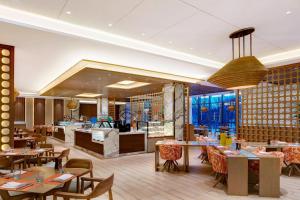 a restaurant with tables and chairs and a counter at Four Points by Sheraton Changchun Hi-Tech Zone in Changchun
