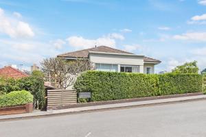 a house with a hedge in front of a street at HSNS1 - Bask in Sydney's Beauty at Harbourview Haven Apt in Sydney