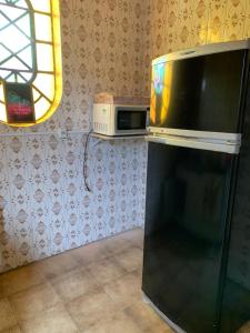 a microwave oven sitting on top of a refrigerator at Hostel 858 in Pelotas +3 photos