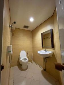 a bathroom with a toilet and a sink at Highlander Apartemen Rajawali in Jakarta