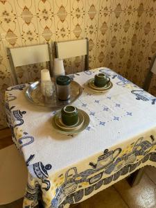 a table with two cups and plates on it at Hostel 858 in Pelotas